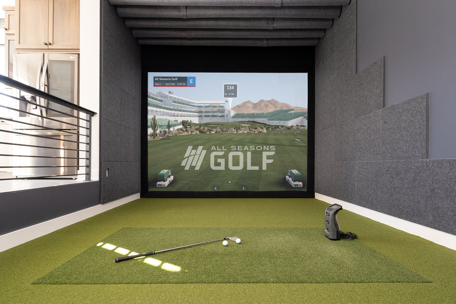 Home golf simulator with an impact screen, hitting mat and enclosure set up in a garage bay